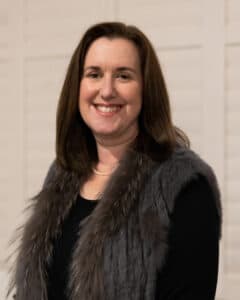 Photo of Dr Georgina Pengilley standing in front of a cream wall. 