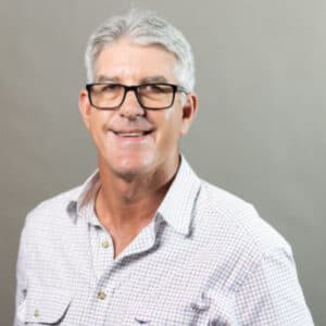 Profile photo of Michael Grieve standing in front of the grey wall. 