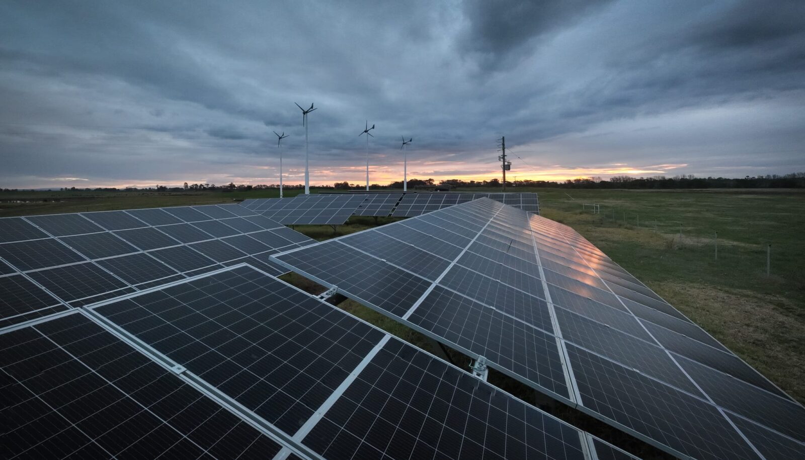 a row of solar panels at sunrise